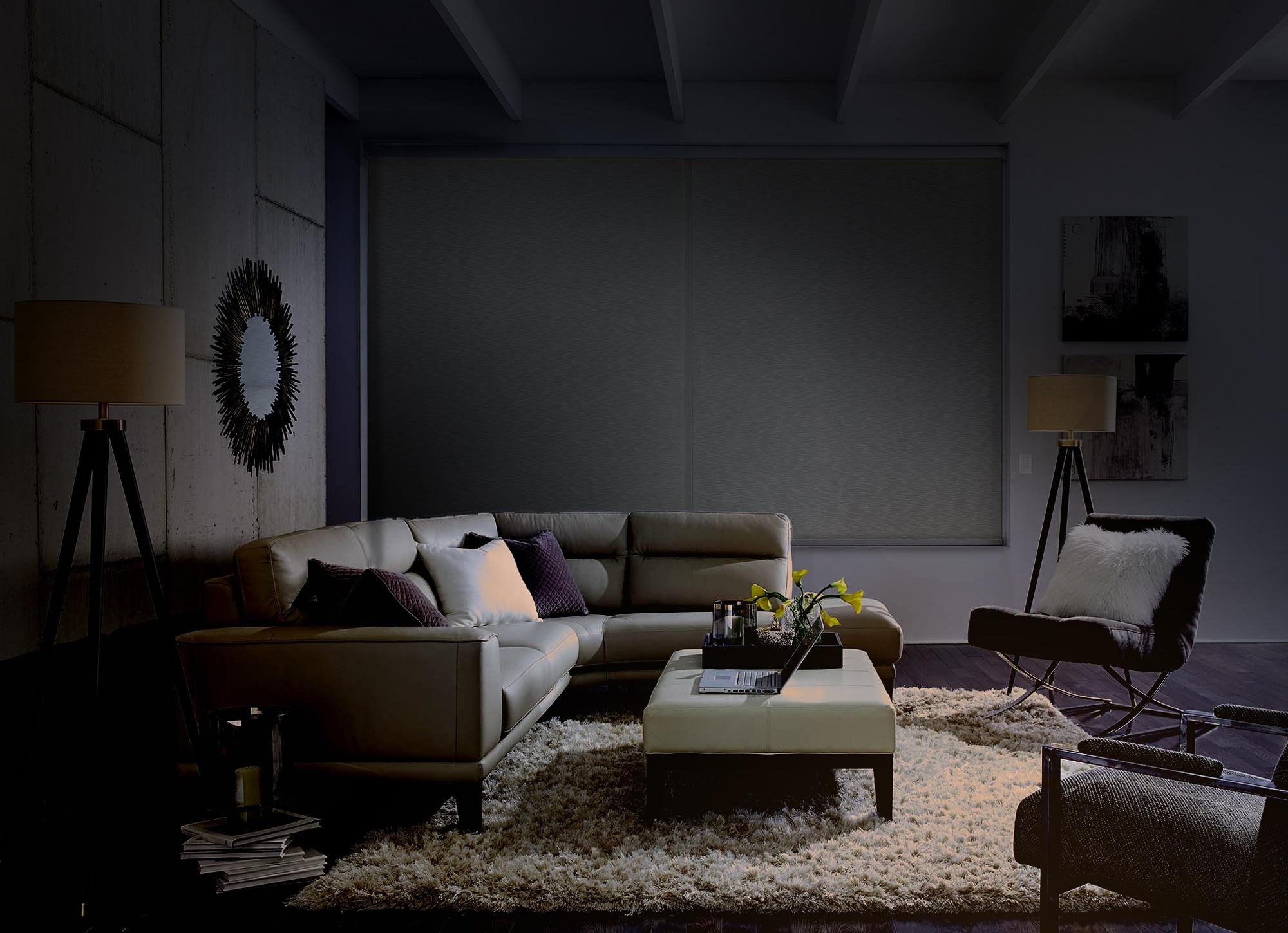 Darkened living room set for a movie night with a white sectional sofa, floor lamps, and a cozy, intimate setting.