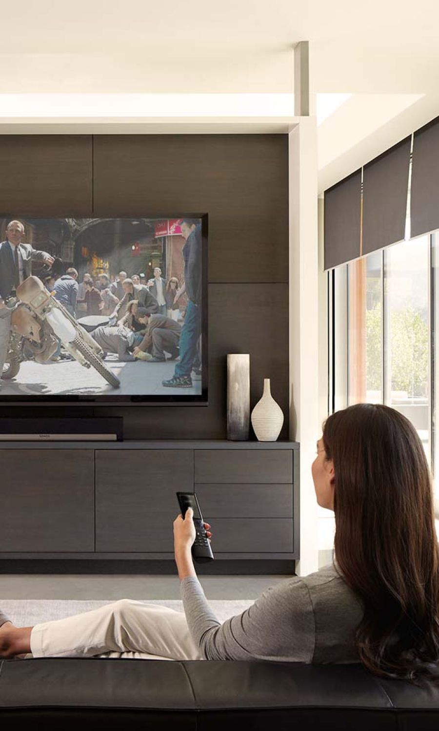 Woman sitting and watching TV in a modern home